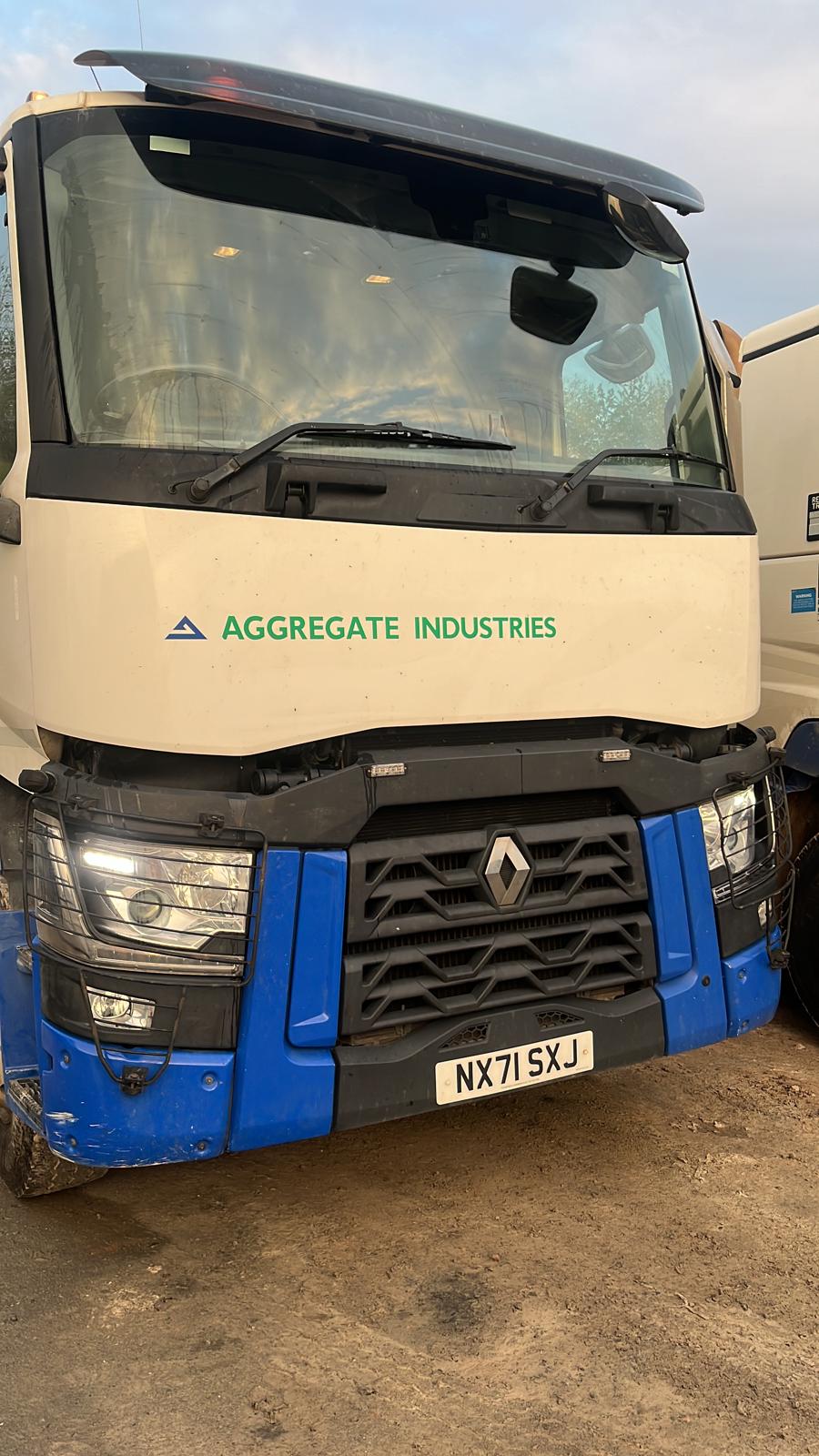 Front view of a blue and white Renault lorry parked in a yard